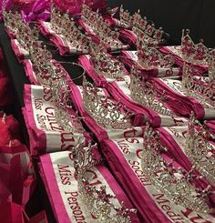 many tiaras and ribbons are lined up together