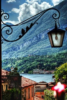 a street light hanging from the side of a building next to a body of water