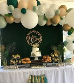 a table topped with lots of desserts and balloons