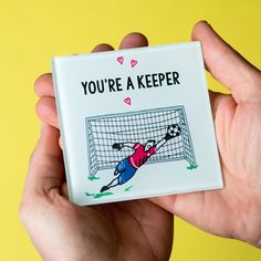 someone holding up a magnet with a soccer goal on it that says, you're a keeper