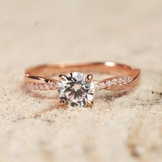 a close up of a diamond ring on sand