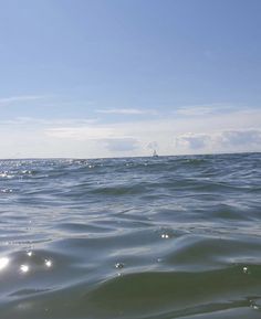 the water is very choppy and blue with some clouds in the sky above it