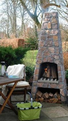 an outdoor fireplace in the middle of a patio