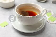 a cup of tea on a saucer next to some sugar cubes