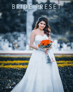 a woman in a white wedding dress holding an orange bouquet and posing for the camera