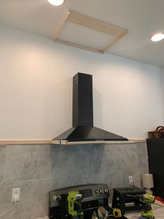 a black stove top oven sitting on top of a kitchen counter next to a wall