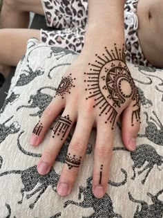 a woman's hand with henna tattoos on it