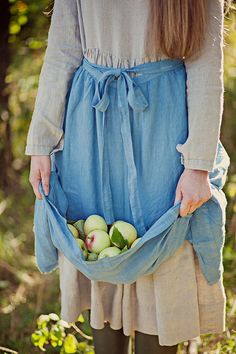 a woman holding a bag full of apples