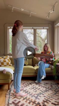 two women are in the living room playing with a frisbee while another woman watches