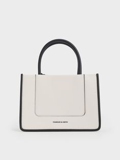 This product is made with at least 20% sustainable materials by weight. CHARLES & KEITH uses recycled, degradable, organic, and water-based materials in our eco-conscious collection.If you are not into big bags, than this smaller Daylla tote will be the perfect alternative. It has everything we love about the classic Daylla tote, including a structured and rectangular silhouette, as well as a roomy interior. This versatile cream version also comes with an additional shoulder strap and can be car Charles And Keith Bags, Charles And Keith, Ikat Pinggang, Structured Bag, Size Chart For Kids, Charles Keith, Big Bags, Cute Bags, Eco Conscious