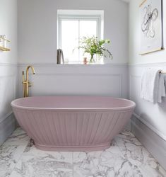 a pink bath tub in a white bathroom