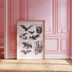 a pink room with an art print on the wall and some bats hanging from it