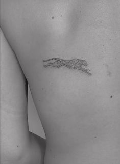 a black and white photo of a cheetah tattoo on the back of a woman