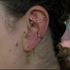 a close up of a person's ear with different types of piercings on it