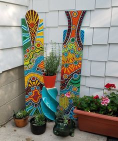 several colorful vases and plants in front of a house