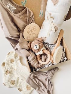 a baby gift box filled with clothes, toys and personalized items for the newborn