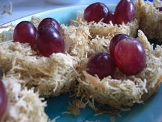 grapes are placed on top of shredded hay in a blue plate, ready to be eaten