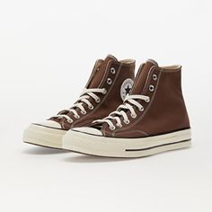 a pair of brown sneakers with white laces