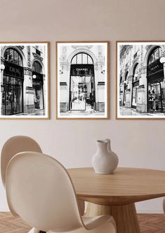 three black and white pictures hanging on the wall above a dining room table with chairs