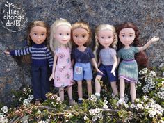 five dolls are standing next to each other in front of some rocks and flowers with the caption free change dolls