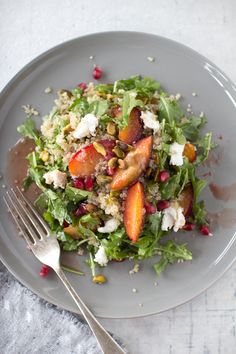 a salad with peaches, feta cheese and pomegranate on top