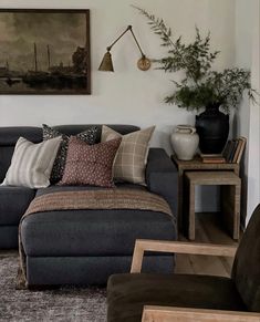 a living room filled with lots of furniture next to a wall mounted painting on the wall