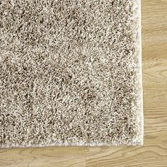 a white rug on top of a wooden floor next to a wood flooring board