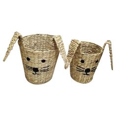 two woven baskets with faces painted on the handles, one has a cat's head