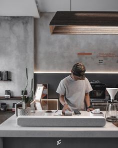 a person standing at a counter in a kitchen