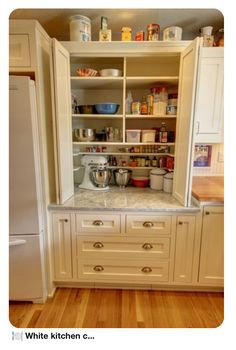 an open cabinet in the middle of a kitchen