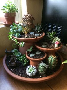 three tiered planters filled with succulents and plants in front of a window