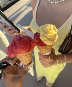 two scoops of ice cream are being held up in front of a woman's face