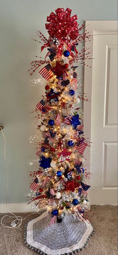 a decorated christmas tree with red, white and blue decorations on it's base