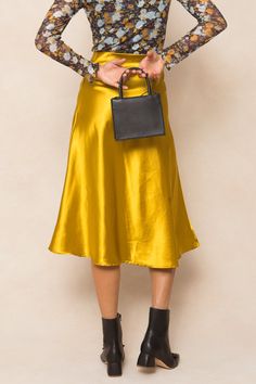 Say hello to the Tiff Skirt in Chartreuse - the perfect combination of style and comfort! This midi-length skirt made from yellow satin fabric is not only elegant but also easy to slip on. And with its stretchy material, you'll never want to take it off. A must-have for any fashion-forward wardrobe. Flowy Satin Skirt For Fall, Chic Gold Flared Skirt, Yellow Evening Skirt For Spring, Elegant Gold Maxi Skirt For Summer, Elegant Long Yellow Skirt, Satin Skirt For Evening In Fall, Satin Skirt For Fall Evening, Chic Yellow Evening Skirt, Elegant Yellow Skirt For Workwear