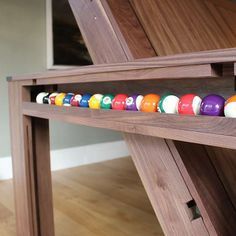 a billiard's table with pool balls on the bottom shelf in front of it