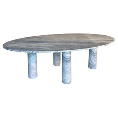 an oval table with four marble pillars on each side and one round in the middle