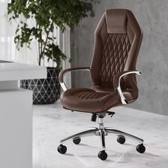 a brown office chair sitting on top of a white counter next to a potted plant