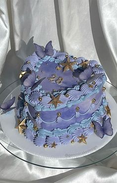 a blue and purple cake sitting on top of a glass plate