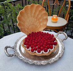 a cake with strawberries in the shape of a heart on a silver platter