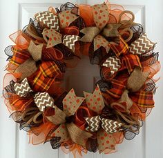 an orange and brown wreath on the front door with polka dots, chevrons and burlocks