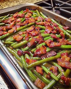 cooked green beans and bacon are in a pan on the stove top, ready to be eaten