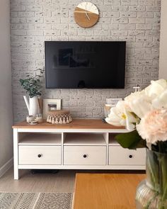 there is a television on the wall and some flowers in vases next to it