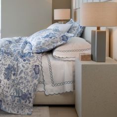 a bed with blue and white linens in a bedroom