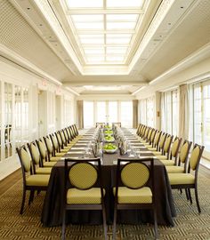 a long table is set up with yellow chairs