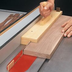 a person using a knife to cut wood with a piece of red tape on it