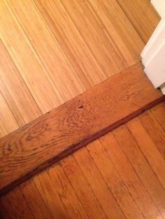 a white toilet sitting on top of a wooden floor