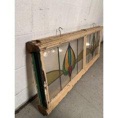 an old window with stained glass hanging on the wall