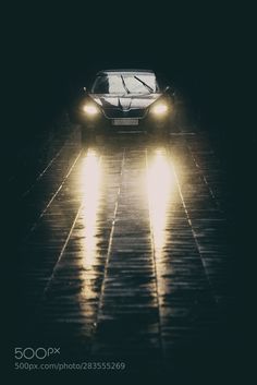 a car driving in the rain at night