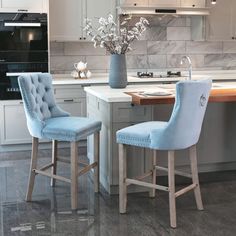 two blue bar stools sitting in front of a kitchen island