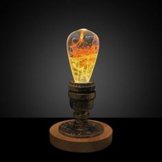 a glowing light bulb sitting on top of a wooden stand